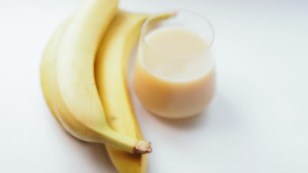Banana juice on a white background. Fresh fruit, selective focus - Footage, Video