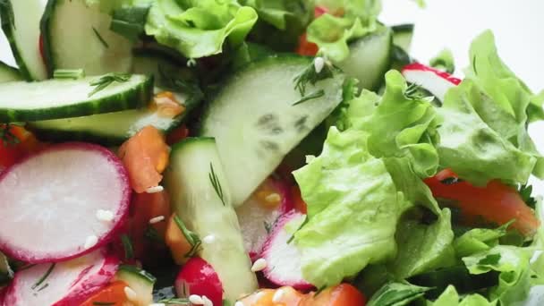 salada com pepinos rabanetes de tomates alface é polvilhada com sementes de gergelim
 - Filmagem, Vídeo