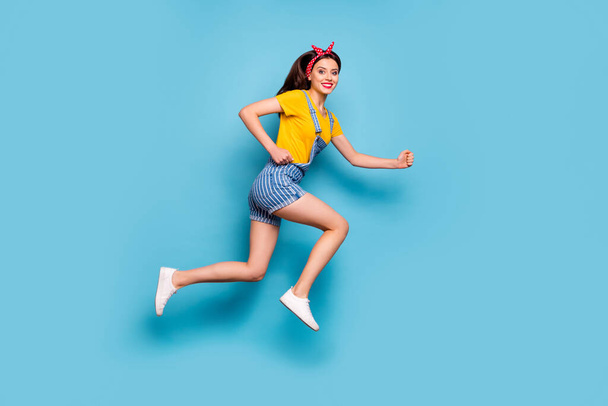 Full length body size view of her she nice attractive lovely cheerful cheery energetic girl jumping running fast isolated over bright vivid shine vibrant blue color background - Foto, afbeelding