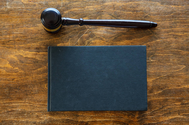 Rechten thema. Rechter hamer en een zwart blanco juridische boek op houten bureau achtergrond, kopieerruimte. Veiling, rechtbanktafel - Foto, afbeelding