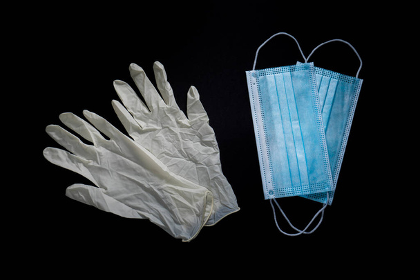 Γάντια και μάσκες για προστασία από ιούς σε μαύρο φόντο - Φωτογραφία, εικόνα
