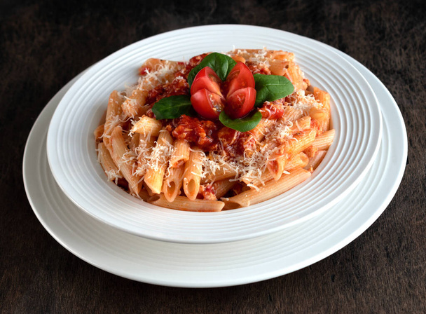 Italian classic Pasta Penne with sauce Bolognaise in a white  plate on wooden board - Foto, Bild