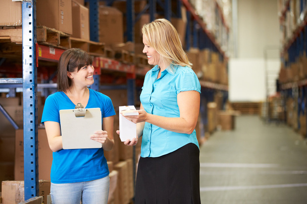 Businesswoman And Female Worker In Distribution Warehouse - Foto, imagen