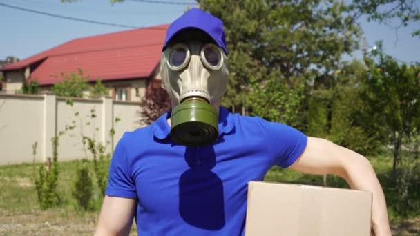 Ταχυμεταφορέας deliveryman σε αναπνευστήρα ή μάσκα αερίου δείχνει μια εντάξει σημάδι στο χέρι του - Πλάνα, βίντεο