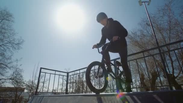 Un jinete bmx solo con capucha negra en rampas en el skatepark
 - Imágenes, Vídeo