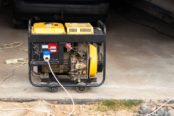 Stand-Alone-Dieselgenerator zur Stromversorgung im Notfall. Gelbe Farbe. Dient nicht einem großen Wohnhaus. - Foto, Bild