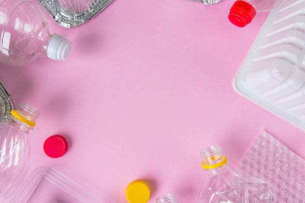 Bottles and containers flat lay on pink background with copy space. Stop plastic concept. Plastic and aluminum waste. Recycling garbage. Say no to plastic. Garbage sorting. Ecological pollution. - Foto, afbeelding