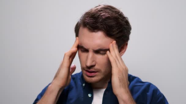 Mężczyzna trzymający ręce na głowie. zbliżenie zmęczony facet mając ból głowy w studio - Materiał filmowy, wideo