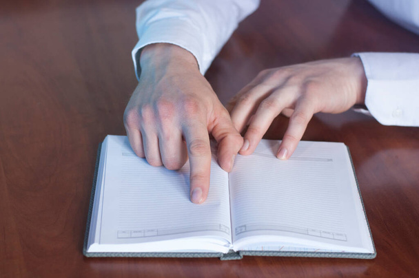 Un hombre de negocios apunta con el dedo a un cuaderno
. - Foto, imagen