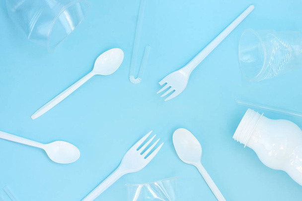 Plastic waste, plastic utensils on a blue background,flat lay. Say no to single use plastic. Ecology environmental care.Copy space for text. - Fotoğraf, Görsel