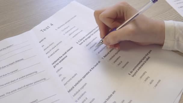 Prüfungsformular auf dem Tisch im Unterricht, Prüfungen ablegen, Hand mit Stift aus nächster Nähe - Filmmaterial, Video