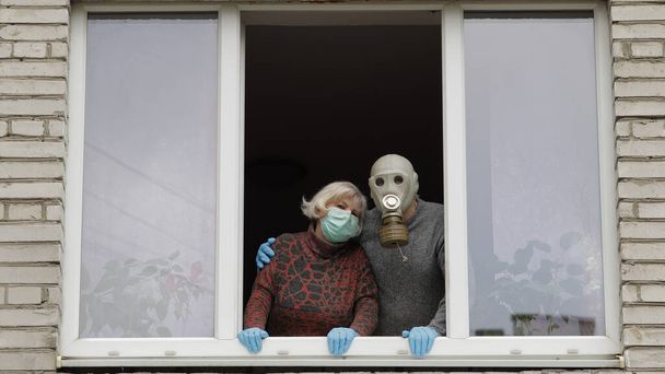 Old grandparents stay at window isolated at home on quarantine. Coronavirus - Foto, Imagen