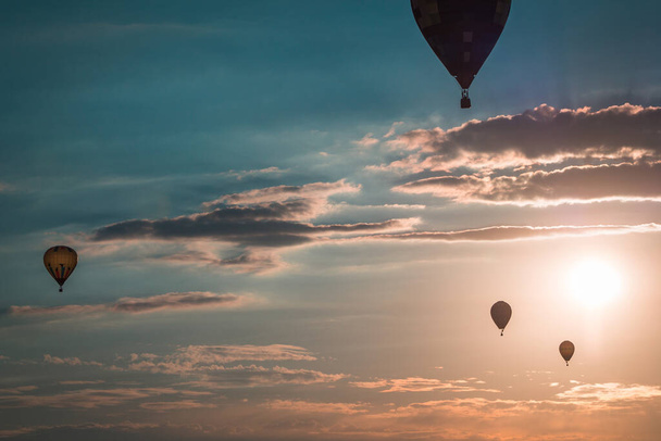 Hot air balloons soaring through the air at sunset at an airshow in Battle Creek Michigan - Photo, image