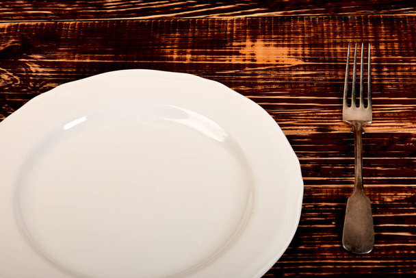 empty white plate and old retro fork - Zdjęcie, obraz