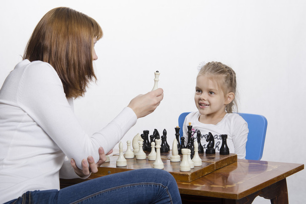 Mère explique le but de la fille des pièces d'échecs
 - Photo, image