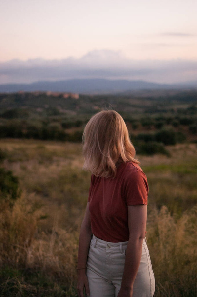 Jeune femme en Toscane paysage en Italie pendant le coucher du soleil avec des couleurs chaudes
 - Photo, image