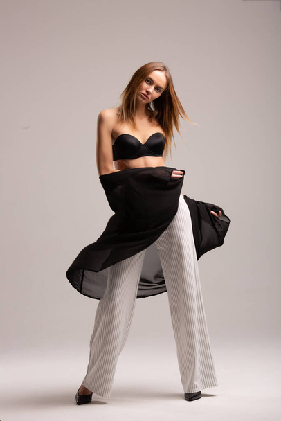 fashion look girl in pants with stripes and black top on plane studio background, supermodel posing, αντίγραφο χώρου - Φωτογραφία, εικόνα