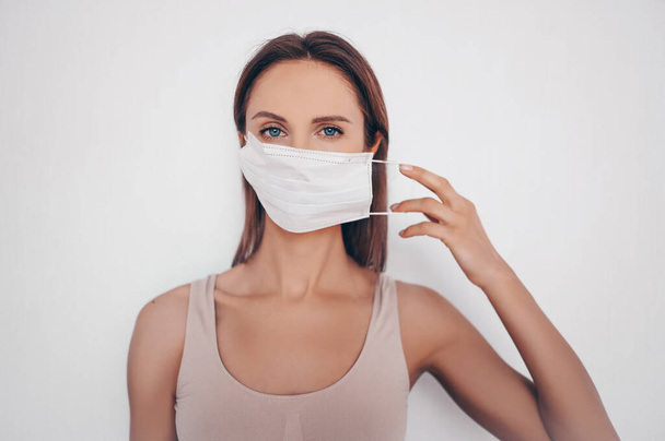 Home fitness. Young fit slim woman in sportswear protection face mask posing during self isolation quarantine. COVID-19 concept to promote stay safe home save lives. Free space for text mockup banner - Fotografie, Obrázek