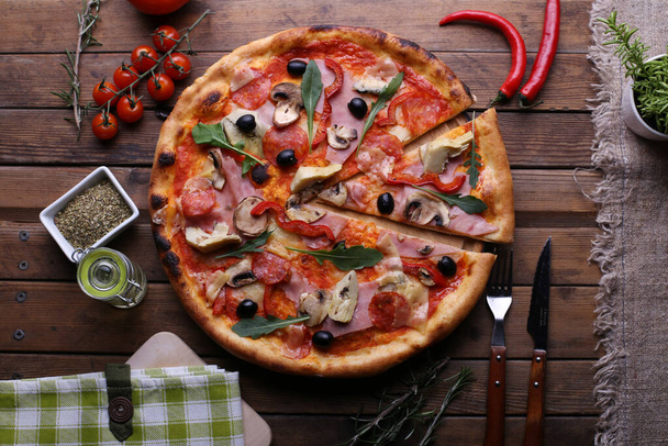 Verse pizza met tomaten, kaas en champignons op houten tafel close-up - Foto, afbeelding