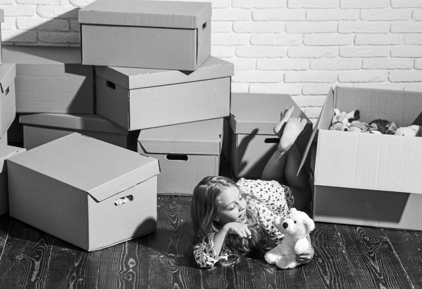 Live Where You Work and Play. purchase of new habitation. happy little girl with toy. Cardboard boxes - moving to new house. playing into new home. new apartment. happy child cardboard box - Zdjęcie, obraz