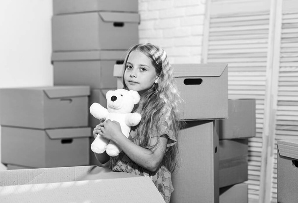 Modern urban lofts. Cardboard boxes - moving to new house. happy child cardboard box. happy little girl with toy. Moving concept. new apartment. purchase of new habitation - Zdjęcie, obraz
