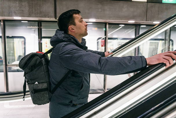 Touriste caucasien avec un sac à dos dans le métro Copenhague, Danemark. Un homme caucasien avec un sac à dos dans l'escalator du métro. Station de métro à Copenhague
. - Photo, image