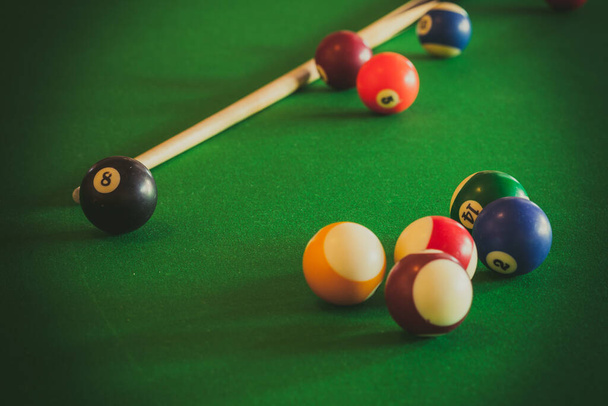 Billiard balls and cue stick on green table. Pool game - Foto, imagen