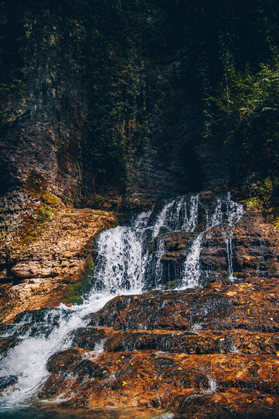 Cachoeira de montanha entre pedras marrons
. - Foto, Imagem