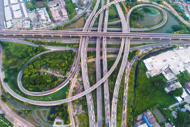 Luchtfoto van knooppunt weg stad met voertuig en groene boom - Foto, afbeelding