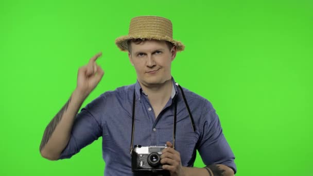 Muotokuva nuoren miehen turisti valokuvaaja osoittaa sormella kameraa. Kroma-avain
 - Materiaali, video