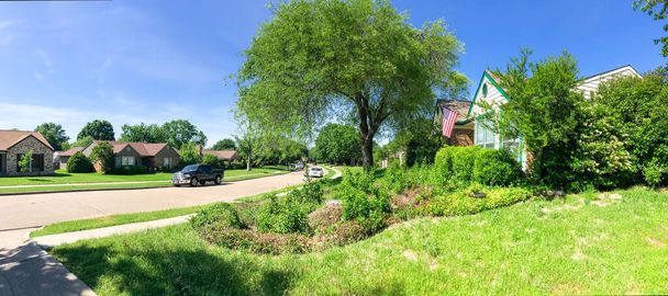 Vista panorámica típico barrio residencial de Texas con casa de una sola planta, acera y césped verde
 - Foto, Imagen