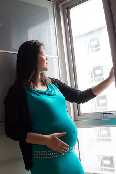 Ázsiai Terhes nők állnak az ablakban a fény, Várakozás koncepció - Fotó, kép