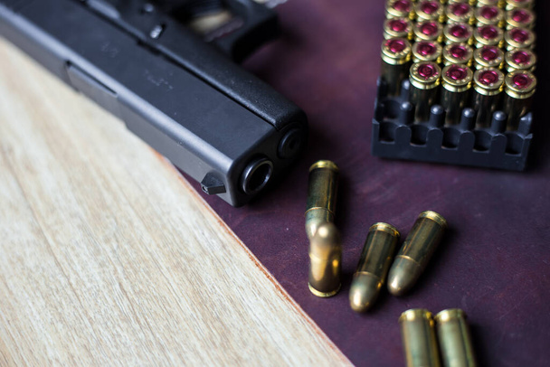 9mm Sub compatto everday portare pistola moderna con proiettile su sfondo in pelle, pistola tascabile
 - Foto, immagini