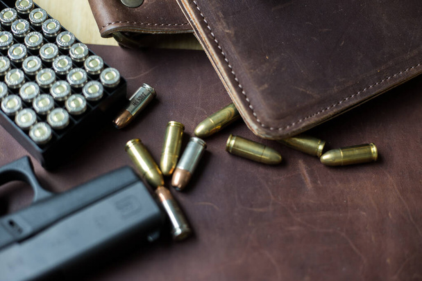 9mm Sub kompaktowy everday nosić nowoczesny pistolet z kulą na skórzanym tle, pistolet kieszonkowy - Zdjęcie, obraz