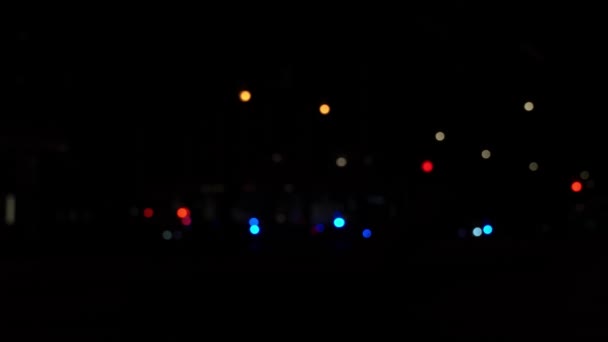 Epätarkka kaupunkimaiseman taustakuva Michigan Avenuesta Chicagon keskustassa, punaiset ja siniset poliisi- ja ambulanssivalot kadunkulmassa reagoivat hämärtyneeseen taustaan
. - Materiaali, video