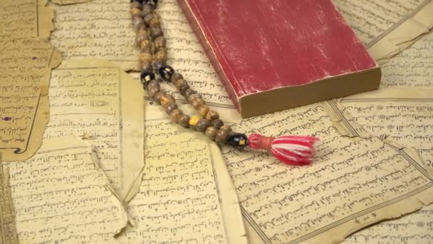 Muslimské modlitební korálky se starodávnými stránkami z Koránu. Islámské a muslimské pojmy. Starověké staré listy papíru z arabské knihy. Efekt přiblížení - Záběry, video