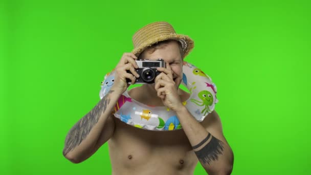 Póló nélküli férfi turista fotós fényképeket készít retro kamerával. Kroma kulcs - Felvétel, videó