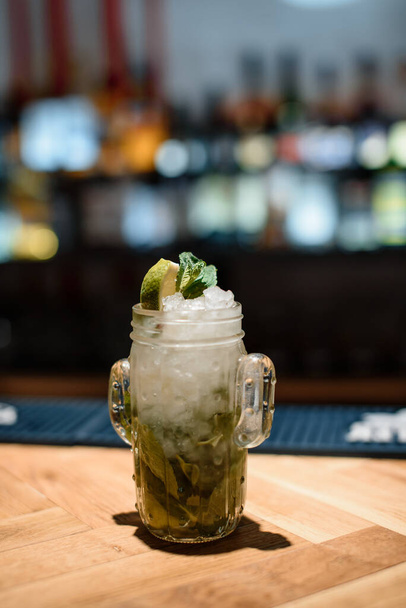 green lime alcohol cocktail on dark bar - 写真・画像