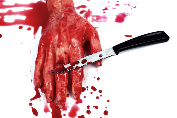 Uma mão ensanguentada a fazer um punho com sangue a pingar isolado no branco
. - Foto, Imagem