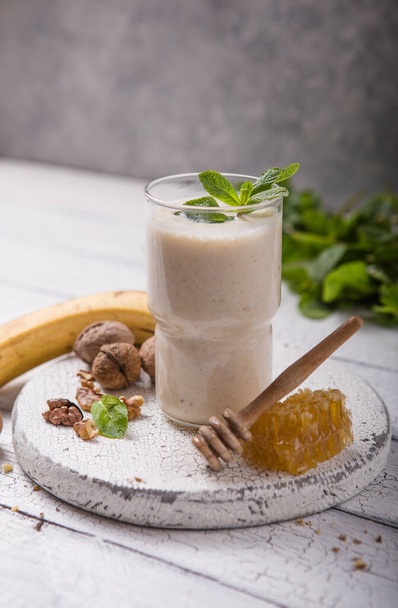 Υγιές πρωινό. Smoothie μπανάνα καρύδια με κολλαγόνο, γάλα καρύδας σε γυάλινο βάζο - Φωτογραφία, εικόνα