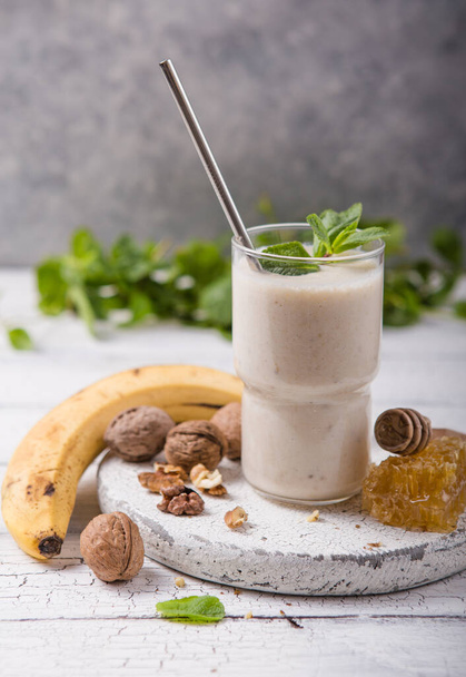 Desayuno saludable. Batido de nueces de plátano con colágeno, leche de coco en frasco de vidrio
 - Foto, Imagen