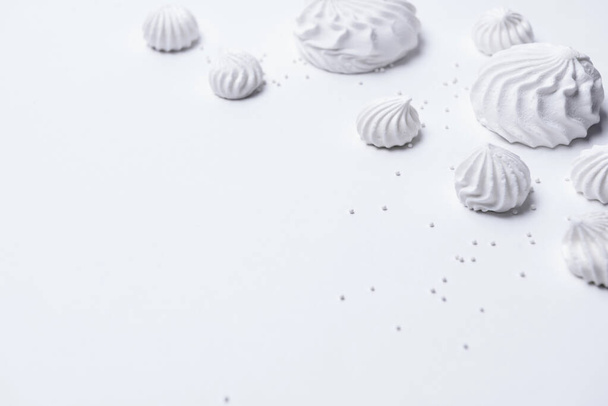 Crispy white twisted meringue and confectionery on white background. Marshmallows, meringue and - Foto, Imagem