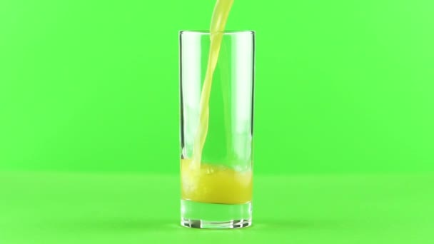 Сок наливается в стекло изолированы на светло-зеленом фоне замедленного движения
 - Кадры, видео