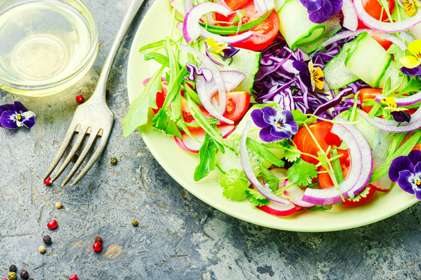 Ensalada con verduras, tomates, col, cebolla y flores comestibles
 - Foto, Imagen