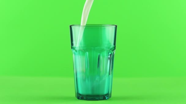 Melk gieten in gefacetteerde groene glas close-up geïsoleerd op licht groene achtergrond Slow motion - Video