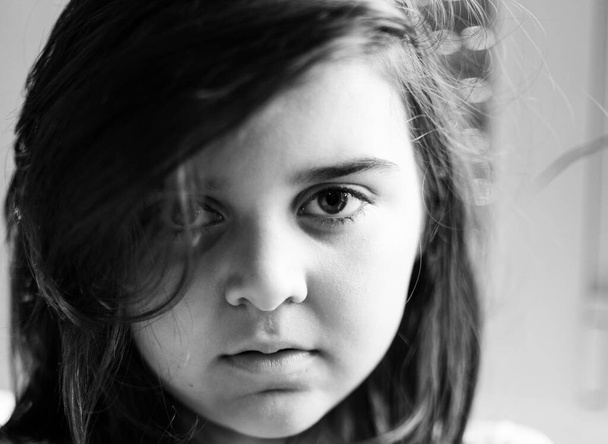 portrait of a beautiful girl in black and white with a deep looking perhaps a little sad because of the confinement due to the coronavirus - Фото, изображение