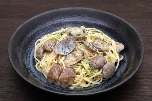 Спагетти Вонголе в тарелке на столе
  - Фото, изображение