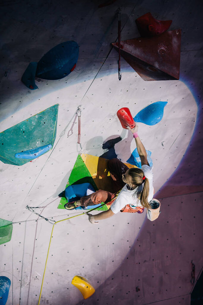 The girl climbs the climbing wall at competitions - Photo, image