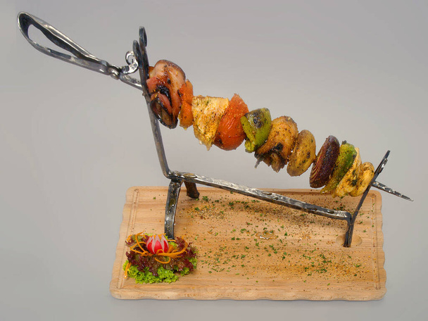 Grilled skewer on a steel skewer with vegetable salad.     - Photo, Image
