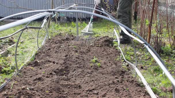 Человек культивирует и убирает сорняки в саду, используя грабли, для дальнейшей посадки овощей. Летний день подходящее время для посадки. социальная помощь фермерам и концепция Дня Земли. Сделайте это сами шаг 2
 - Кадры, видео